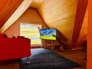 a living room with a flat screen tv in a attic at Waterfall View in Kandersteg