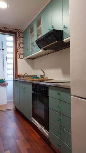 eine Küche mit grünen Schränken und einem schwarzen Geschirrspüler in der Unterkunft apartamento al mar cullera florazar in Cullera