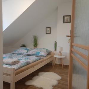 1 dormitorio con cama y pared blanca en Kralovak, en Králŭv Dvŭr