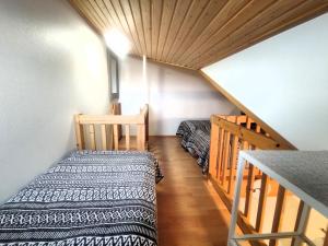 a small room with a bed and a staircase at Leviloma - 27m2 B - Levi huoneisto loma-asunto Levistar majoitus - Levi apartment Levistar accommodation in Levi