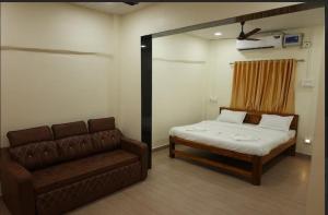 a bedroom with a bed and a couch in it at SAVI 4BHK VILLA ALIBAUG in Alibaug