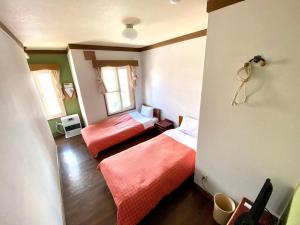 a room with two beds and two windows at Grandpapa in Kutchan