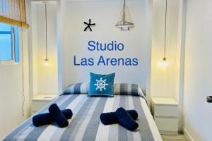 a bedroom with a bed with blue pillows at El Castillito Studios in Buenavista del Norte