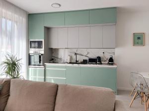 a living room with a couch and a kitchen at Linden Apartman 001 - Adults Only in Mosonmagyaróvár