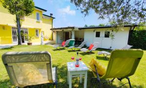 un patio con sillas, una mesa y una casa en Villa con giardino privato, tre camere, due bagni, en Manerba del Garda