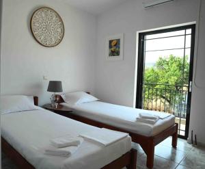 Duas camas num quarto com uma janela em Άνετο διαμέρισμα για 4 με θέα em Erétria