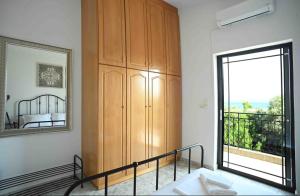 ein Schlafzimmer mit einem Holzschrank und einem großen Fenster in der Unterkunft Άνετο διαμέρισμα για 4 με θέα in Eretria