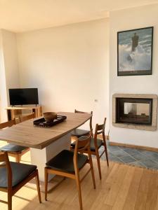 a dining room with a table and chairs and a fireplace at Maison au dessus de la plage 6 personnes in Saint-Michel-en-Grève