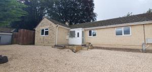 a house with a white door in a gravel yard at FREE Parking, Stylish and Spacious Bungalow in Bath