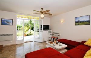 sala de estar con sofá rojo y mesa en Villa con giardino privato, tre camere, due bagni, en Manerba del Garda