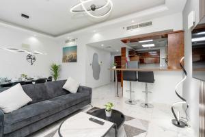 uma sala de estar com um sofá e uma mesa em Marina Yacht Club Views - 3BR Modern Furnished no Dubai