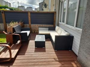 eine Terrasse mit einem Sofa, Stühlen und einem Tisch in der Unterkunft Cichy I uroczy pokój in Newtongrange