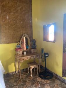 a dressing room with a mirror and a stool at Jana's Homestay in Sidemen
