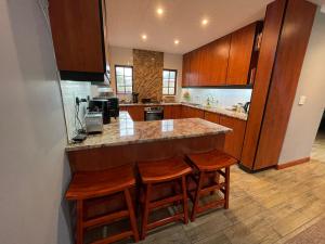 a kitchen with a counter and some wooden cabinets at OAK HOUSE, Entire holiday home, Self catering, fully equipped, double storey, 3 bedroom, 2 bathroom, outside entertainment, Braai area, 300sqm home in Hillcrest +25 photos