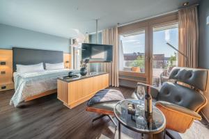 Habitación de hotel con cama y TV en hirschen dornbirn - das boutiquestyle hotel en Dornbirn