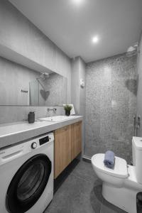 ein Badezimmer mit einer Waschmaschine und einem WC in der Unterkunft Feidias Apartment - 1 bedroom in Thessaloniki