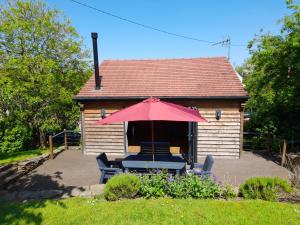 una casa con tavolo, sedie e ombrellone di Tanners Lodge a Bewdley