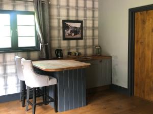 a kitchen with a counter with stools and a table at Tanners Lodge in Bewdley