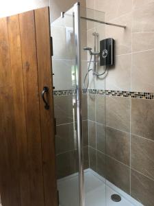 a shower with a glass door in a bathroom at Tanners Lodge in Bewdley