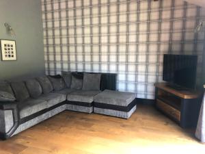 a living room with a couch and a tv at Tanners Lodge in Bewdley