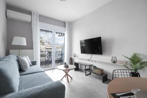 ein Wohnzimmer mit einem Sofa und einem TV in der Unterkunft Feidias Apartment - 1 bedroom in Thessaloniki