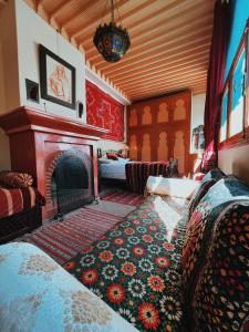 Riad Al Nour في مراكش: غرفة معيشة بها موقد وأريكة وسرير