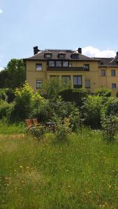 a building in the background with a field of grass at FW-Talblick in Annaberg-Buchholz
