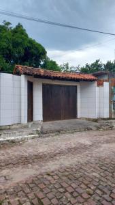 une petite maison avec une grande porte devant elle dans l'établissement Residencial Maria de Lourdes, à Ibicoara