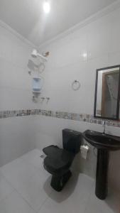baño con aseo negro y lavamanos en Residencial Maria de Lourdes, en Ibicoara