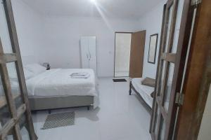um quarto branco com uma cama e um espelho em Residencial Maria de Lourdes em Ibicoara
