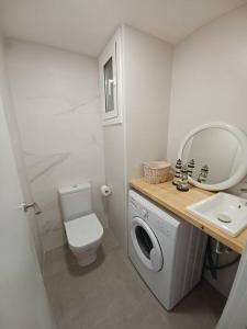 La salle de bains blanche est pourvue de toilettes et d'un lavabo. dans l'établissement Apartamento Roc Mar, à Llafranc