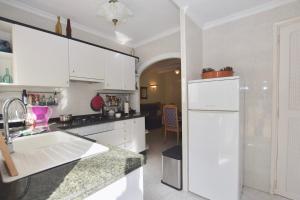 a kitchen with white cabinets and a white refrigerator at Apartments in a "VILLA VISTA JAVEA" in Jávea