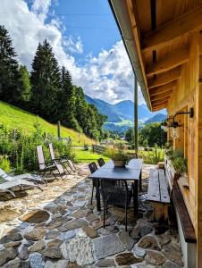 a patio with a table and chairs and mountains at Chalet Grittelihus, large bathroom, Lots of living space, nahe Interlaken in Diemtigen