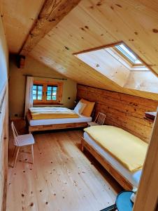 a bedroom with two beds in a wooden cabin at Chalet Grittelihus, large bathroom, Lots of living space, nahe Interlaken in Diemtigen