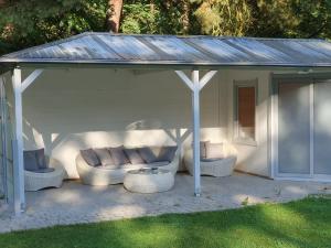 einem Pavillon mit Stühlen und einem Tisch im Hof in der Unterkunft Ferienwohnung Hellwig in Wendisch Rietz