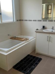 ein Badezimmer mit einer Badewanne und einem Waschbecken in der Unterkunft Copper Shores Holiday House in Wallaroo