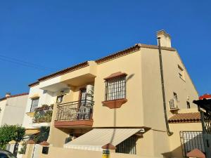 Un grand bâtiment blanc avec balcon et ciel bleu est disponible. dans l'établissement Málaga casa grande familiar, à Malaga