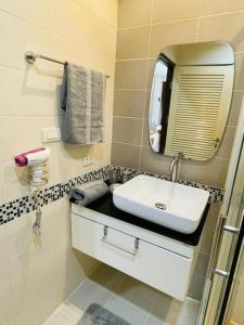 een badkamer met een wastafel en een spiegel bij Brand New Naithon Condo C411 in Nai Thon Beach