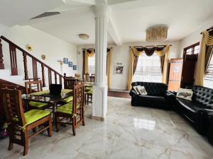 a living room with a couch and a table and chairs at Thuring's Holiday Bungalow in Nuwara Eliya