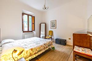 a bedroom with a bed and a chair in it at Casa Lola nel centro storico di Bolognola in Pintura di Bolognola