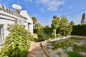 a garden with a cactus and bushes next to a house at Apartments in a "VILLA VISTA JAVEA" in Jávea