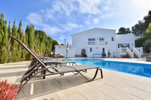 a villa with a pool in front of a house at Apartments in a house in Jávea