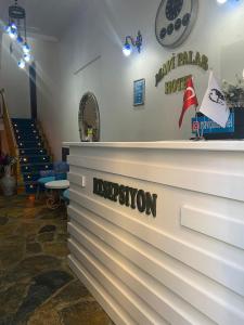 un banco blanco con el nombre de una estación de hockey en MAVİ PALAS HOTEL, en Büyükada