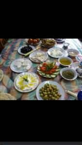 une table avec des assiettes de nourriture sur une table dans l'établissement Hilton Wadi rum, à Disah