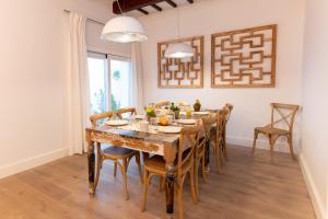 Can Roca Nou في ماهون: غرفة طعام مع طاولة وكراسي خشبية