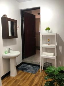 un baño con lavabo y espejo en Comfort Stay, en Nakuru 35 fotos más