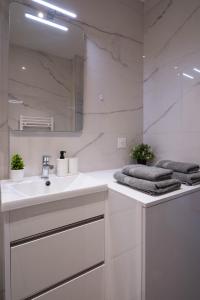 a white bathroom with a sink and a mirror at Studio calme et climatisé au cœur de Cannes in Cannes