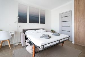 a white bedroom with a bed and a desk at Studio calme et climatisé au cœur de Cannes in Cannes