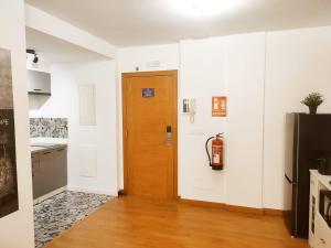 a hallway with a wooden door and a kitchen at milla sonsuites in Milladoiro