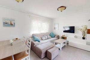 een woonkamer met een bank en een tafel bij Beautiful 3 bed villa on Mar Menor golf resort in Torre-Pacheco